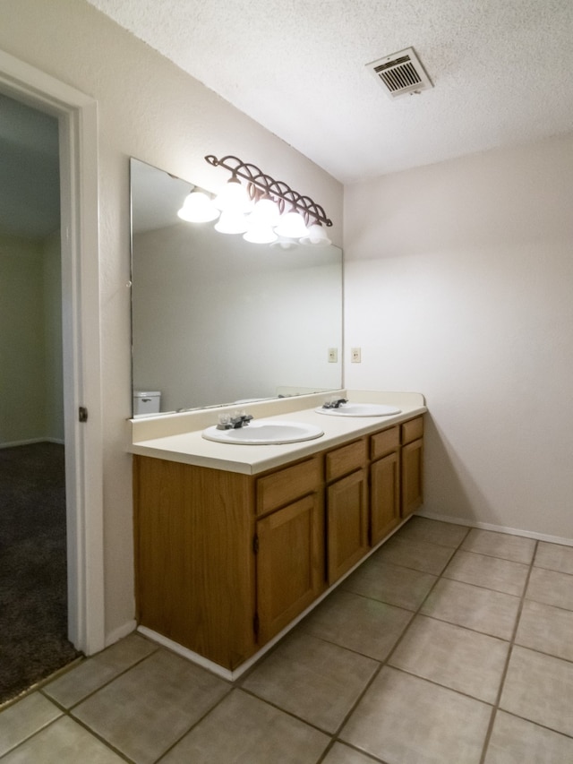 bathroom featuring tile patterned flooring, vanity, and a textured ceiling