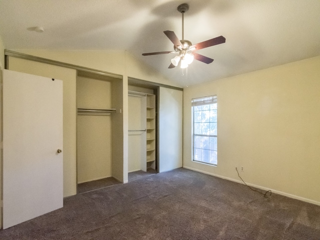 unfurnished bedroom featuring ceiling fan, dark colored carpet, and vaulted ceiling