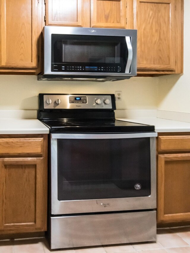 kitchen with stainless steel appliances and light tile patterned flooring