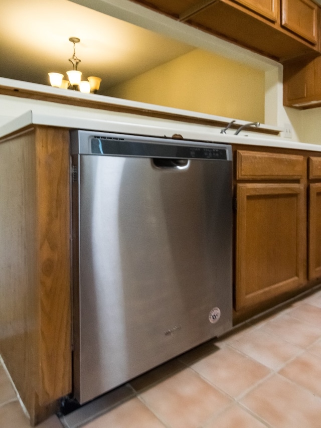 kitchen featuring stainless steel dishwasher, light tile patterned flooring, a chandelier, and decorative light fixtures