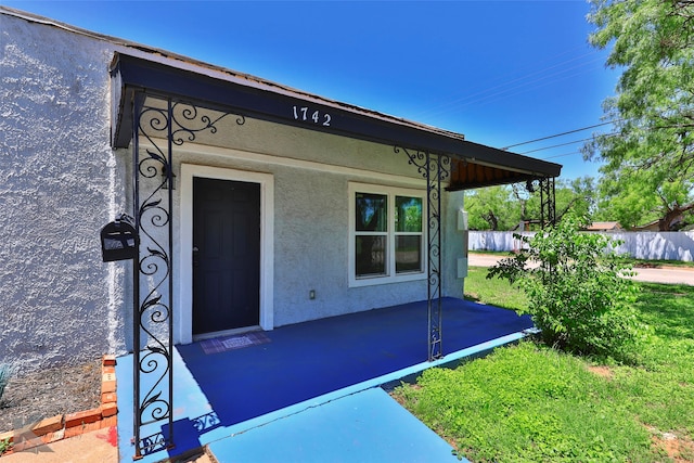 view of exterior entry featuring a yard