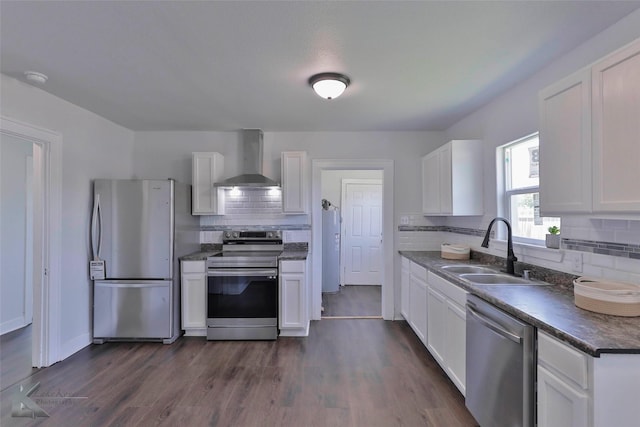 kitchen with sink, white cabinets, dark hardwood / wood-style flooring, stainless steel appliances, and wall chimney range hood