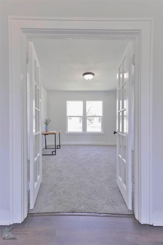 corridor with french doors and wood-type flooring