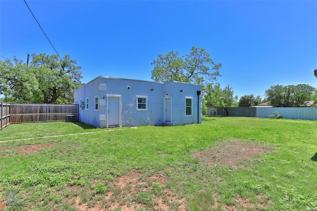 rear view of house featuring cooling unit and a yard