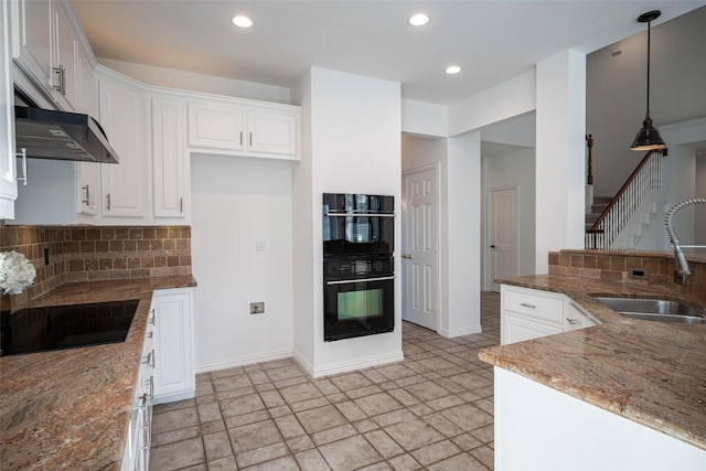 kitchen featuring white cabinetry, sink, decorative light fixtures, and black appliances