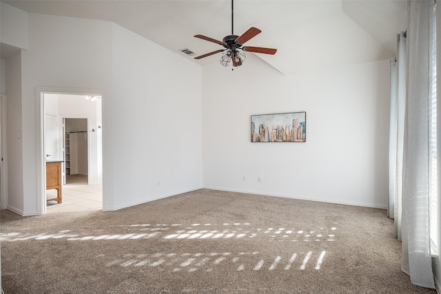 carpeted empty room featuring ceiling fan and high vaulted ceiling