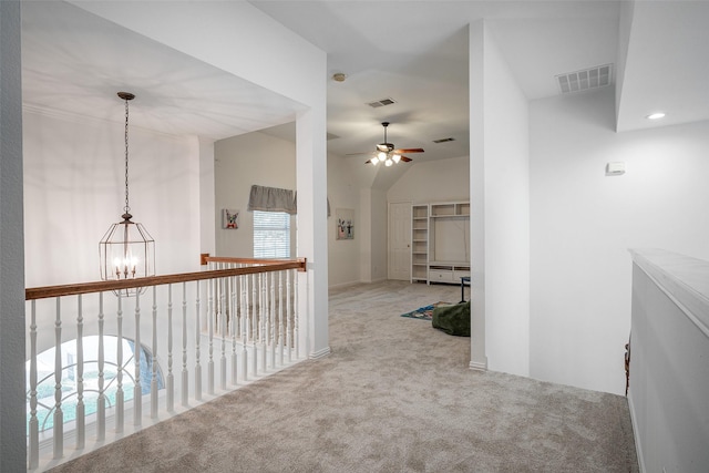 hall featuring carpet flooring, a chandelier, and vaulted ceiling