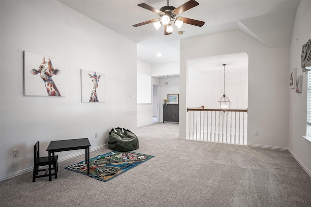 sitting room with carpet flooring and ceiling fan with notable chandelier