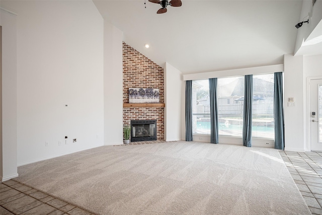 unfurnished living room featuring a brick fireplace, light carpet, and high vaulted ceiling