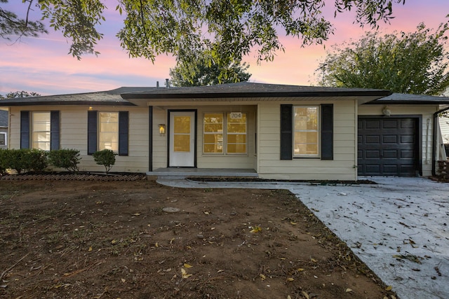 ranch-style home with a garage and covered porch