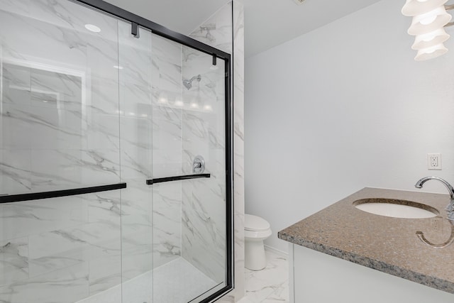 bathroom featuring a shower with door, vanity, and toilet