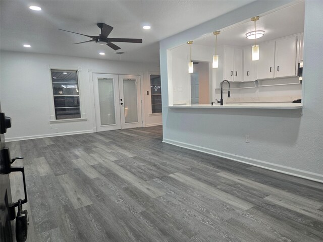 kitchen with white cabinetry, decorative light fixtures, dark hardwood / wood-style floors, sink, and ceiling fan