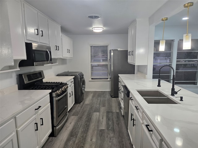 kitchen with white cabinetry, appliances with stainless steel finishes, decorative light fixtures, sink, and dark wood-type flooring