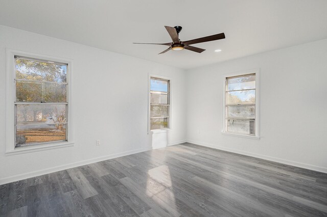 spare room with dark wood-type flooring, ceiling fan, and plenty of natural light