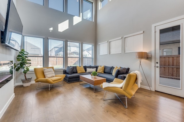 living room with light hardwood / wood-style floors and a high ceiling