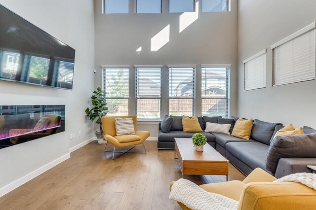 living room featuring a high ceiling and light wood-type flooring