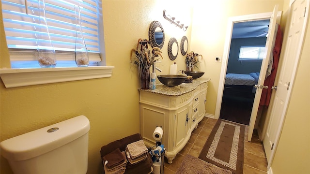 bathroom with toilet, vanity, and tile patterned floors