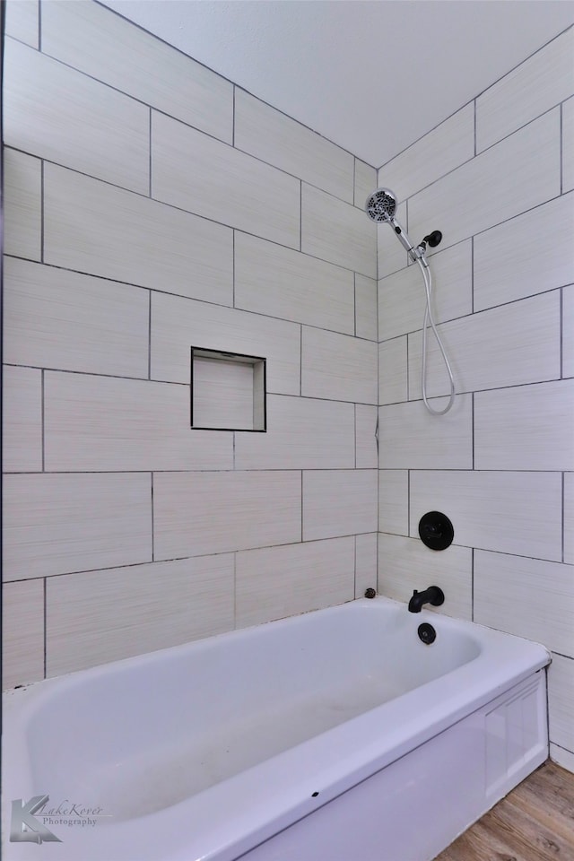 bathroom featuring hardwood / wood-style floors and tiled shower / bath combo