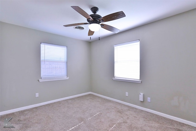 empty room with ceiling fan and light carpet