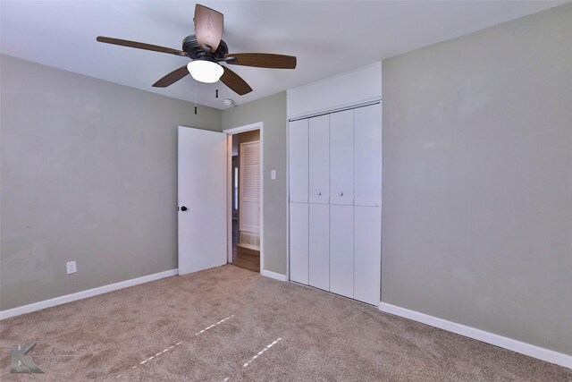 unfurnished bedroom with ceiling fan, light carpet, and a closet