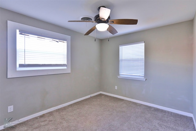 carpeted spare room featuring ceiling fan