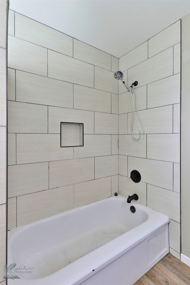 bathroom featuring tiled shower / bath combo and hardwood / wood-style flooring