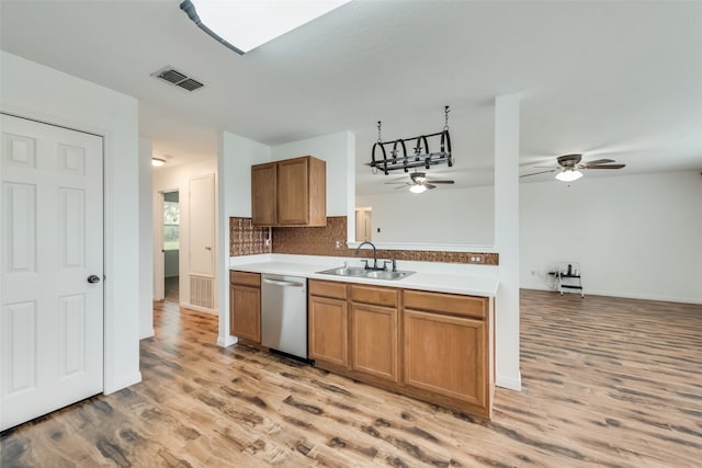 kitchen featuring tasteful backsplash, sink, stainless steel dishwasher, and light wood-type flooring