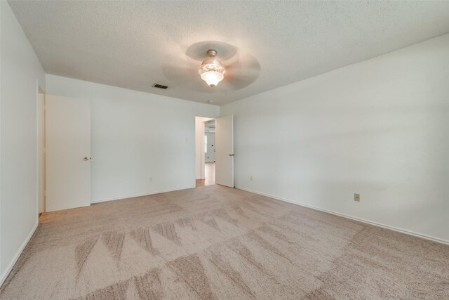 empty room with light carpet, a textured ceiling, and ceiling fan