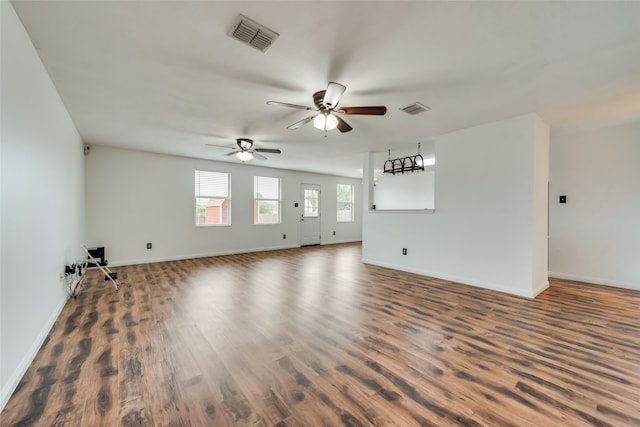 unfurnished living room with ceiling fan and dark wood-type flooring