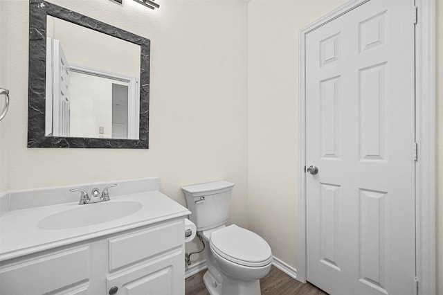 bathroom with wood-type flooring, vanity, and toilet