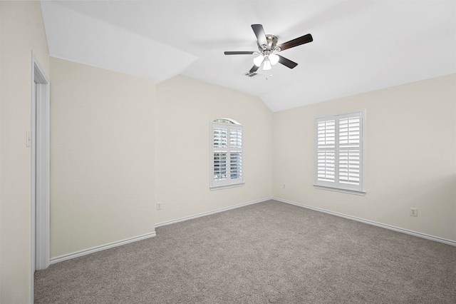 empty room featuring carpet flooring, a wealth of natural light, ceiling fan, and vaulted ceiling