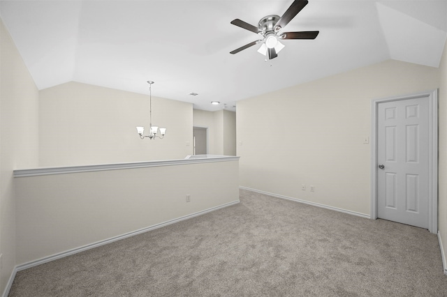 carpeted empty room with ceiling fan with notable chandelier and lofted ceiling