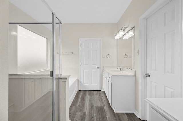 bathroom with vanity, shower with separate bathtub, and hardwood / wood-style floors