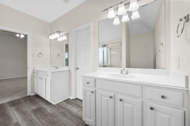 bathroom with vanity, hardwood / wood-style flooring, and lofted ceiling