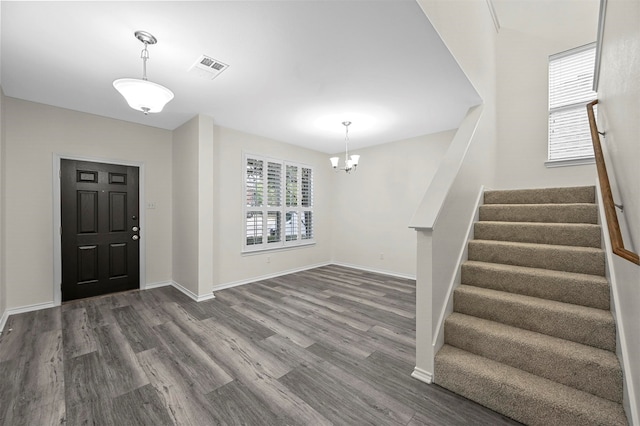 foyer entrance with an inviting chandelier and dark hardwood / wood-style floors