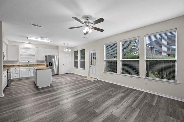 kitchen featuring white cabinetry, decorative light fixtures, stainless steel fridge with ice dispenser, dark wood-type flooring, and a center island