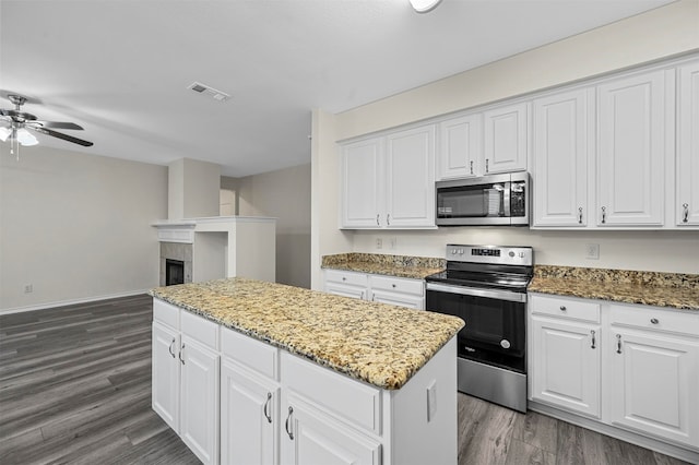 kitchen featuring dark hardwood / wood-style flooring, a kitchen island, white cabinets, and stainless steel appliances