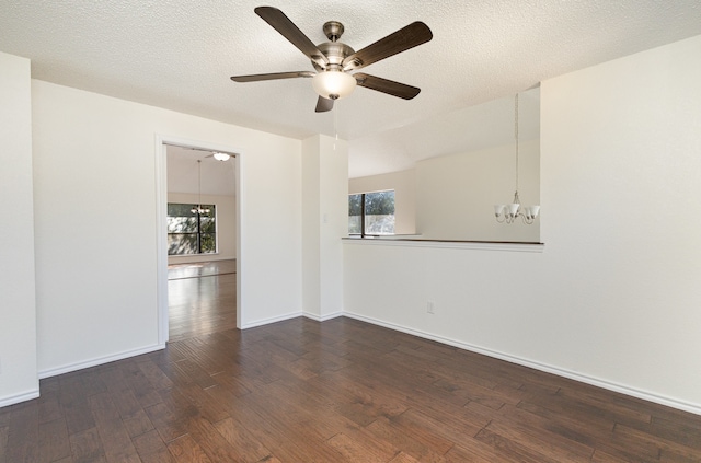 spare room with ceiling fan with notable chandelier, dark hardwood / wood-style floors, and a textured ceiling