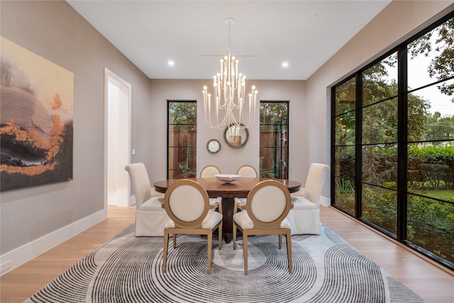 dining space featuring light wood-type flooring and an inviting chandelier