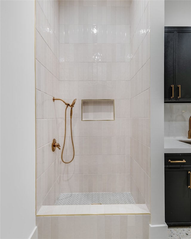 bathroom featuring tiled shower and vanity