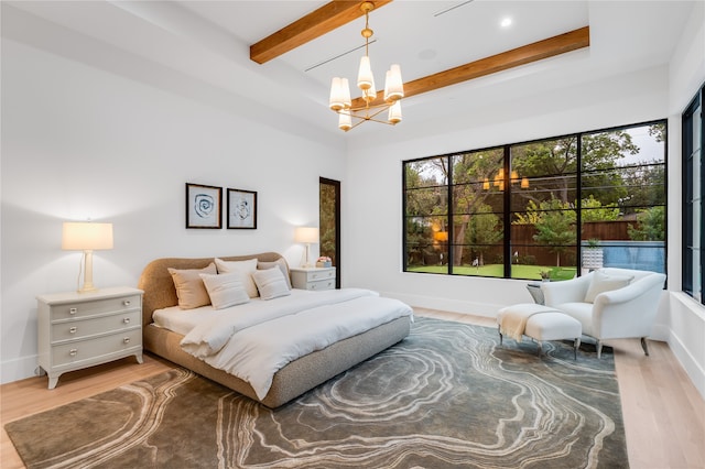 bedroom with beamed ceiling, an inviting chandelier, and hardwood / wood-style flooring