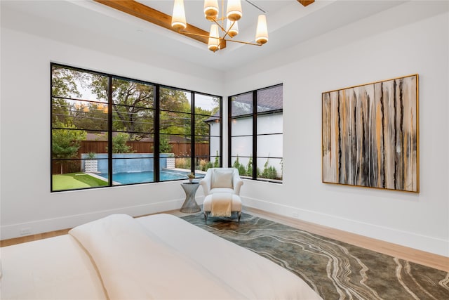 bedroom featuring wood-type flooring, multiple windows, a chandelier, and beam ceiling