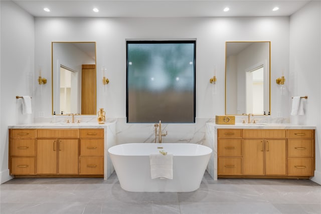 bathroom featuring vanity, a tub to relax in, and tile walls