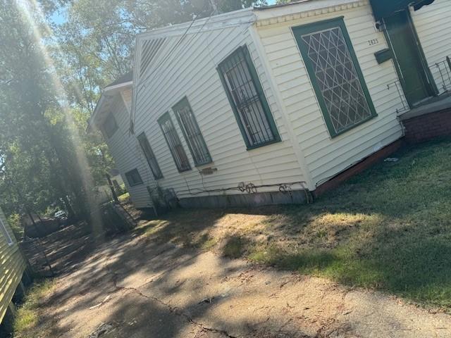 view of side of property with a lawn