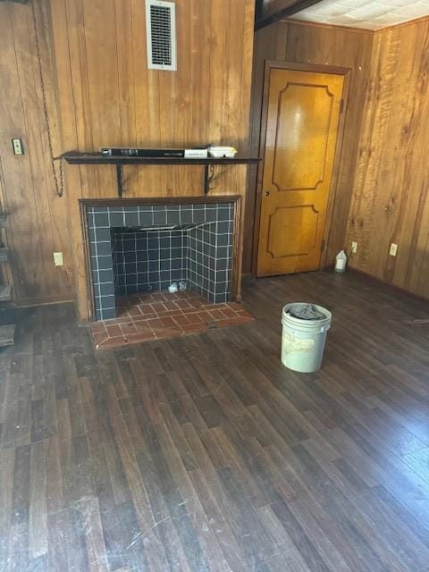 unfurnished living room with dark hardwood / wood-style flooring and wood walls