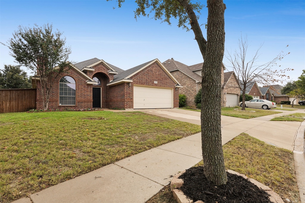 view of front of property featuring a garage and a front lawn