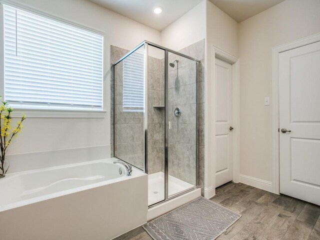 bathroom with hardwood / wood-style floors and separate shower and tub