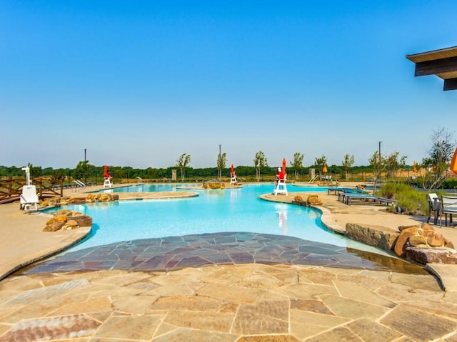 view of swimming pool featuring a patio and a hot tub