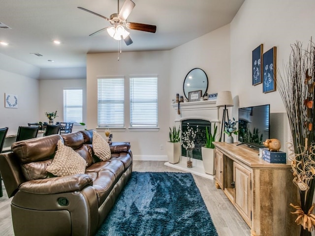 living room with ceiling fan and light wood-type flooring