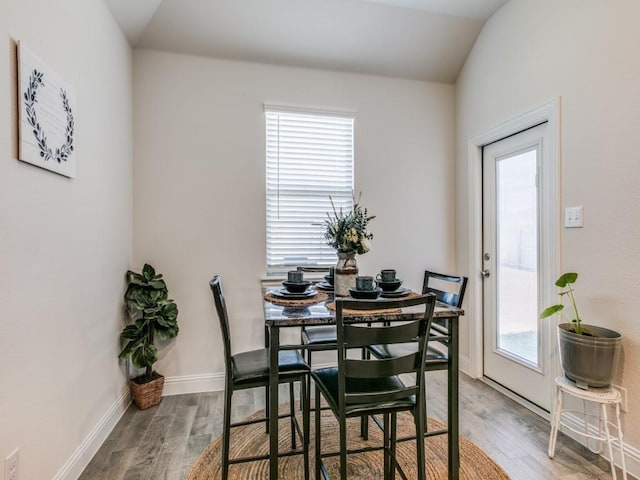 dining area featuring vaulted ceiling and hardwood / wood-style flooring